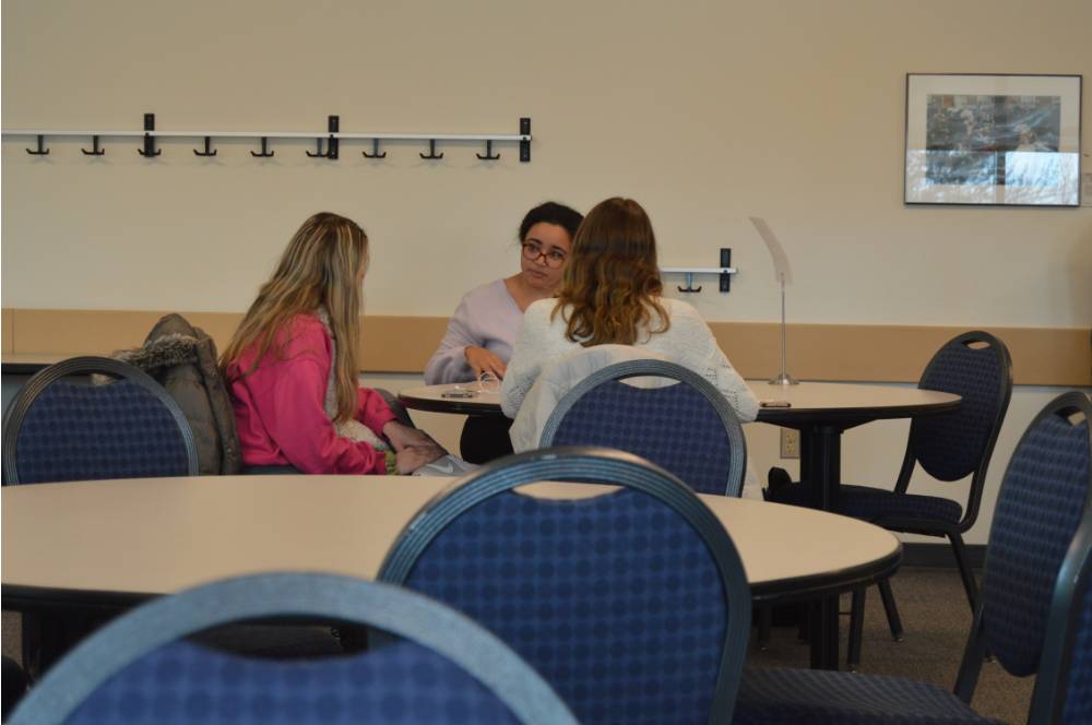 A photo of an alumna talking to two students at the 30 Minute Mentors Event